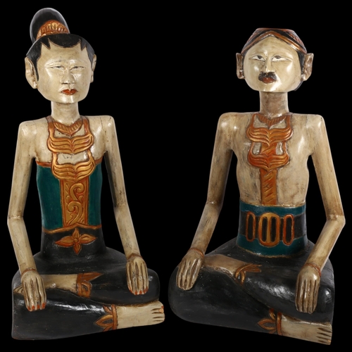 815 - A pair of modern carved wood seated Thai figures, unsigned, H65cm (2)