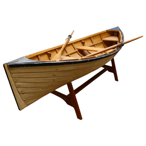 961 - A clinker built model dinghy on stand with oars, L152cm