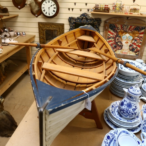 961 - A clinker built model dinghy on stand with oars, L152cm