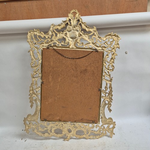 303 - An ornate gilt-metal framed wall mirror, overall 91cm x 63cm