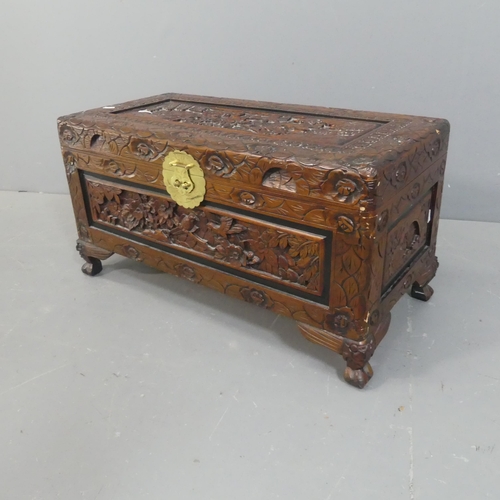 2138 - A Chinese camphorwood blanket box of small form, with all-over carved decoration and brass mount. Wi... 