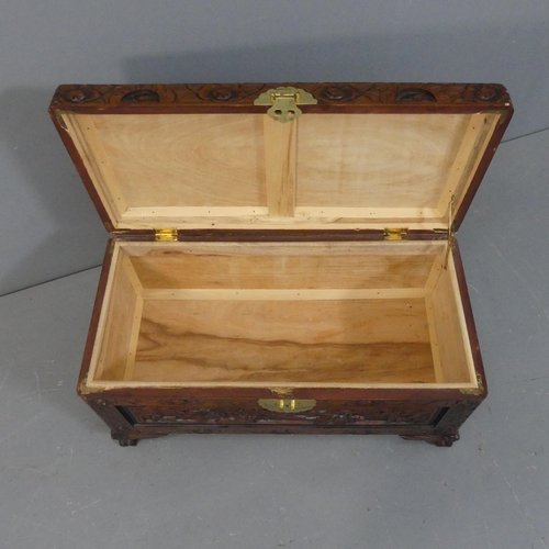 2138 - A Chinese camphorwood blanket box of small form, with all-over carved decoration and brass mount. Wi... 