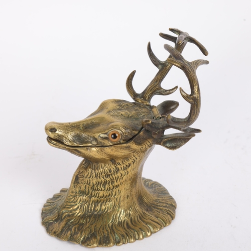 21 - Victorian brass deer's head design inkwell, with pen rest antlers, hinged lid and glass eyes, height... 