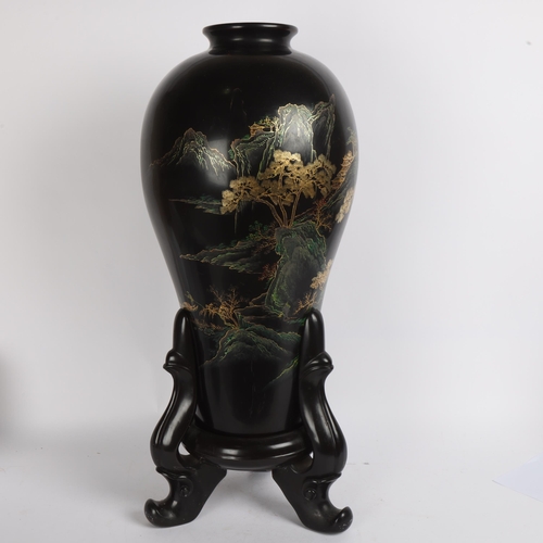 89 - A large Chinese black lacquered wood vase on stand, with gilt mountain landscape decoration, overall... 