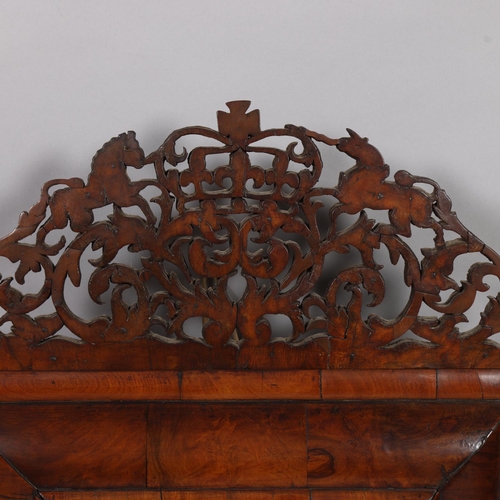 37 - An 18th century walnut cushion-framed wall mirror, with pierced coat of arms pediment, overall heigh... 