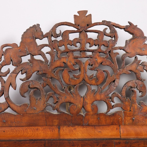 37 - An 18th century walnut cushion-framed wall mirror, with pierced coat of arms pediment, overall heigh... 