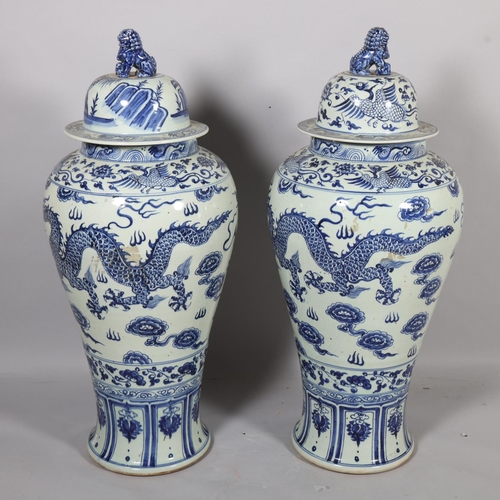 47 - A large pair of Chinese blue and white porcelain jars and covers, with dragon decoration and dog of ... 