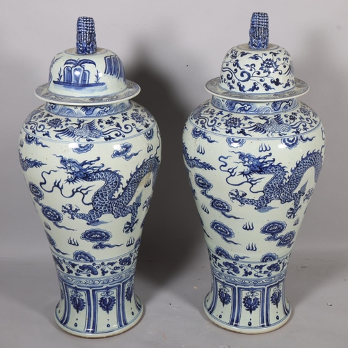 47 - A large pair of Chinese blue and white porcelain jars and covers, with dragon decoration and dog of ... 