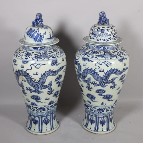 47 - A large pair of Chinese blue and white porcelain jars and covers, with dragon decoration and dog of ... 