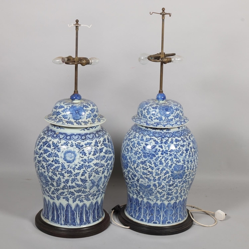 52 - A large pair of Chinese blue and white porcelain lamps on wooden bases, height to top of covers 65cm