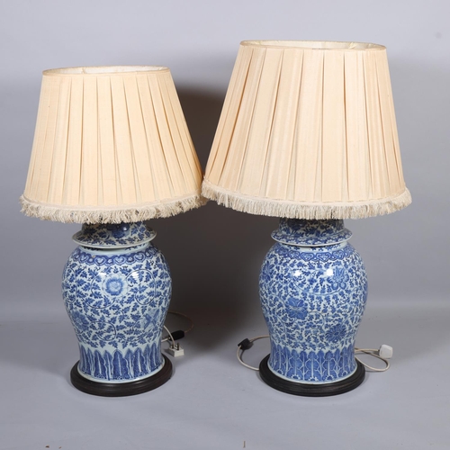 52 - A large pair of Chinese blue and white porcelain lamps on wooden bases, height to top of covers 65cm