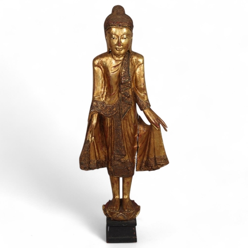 58 - A Burmese 20th century carved giltwood standing Buddha, on lotus base, height 100cm