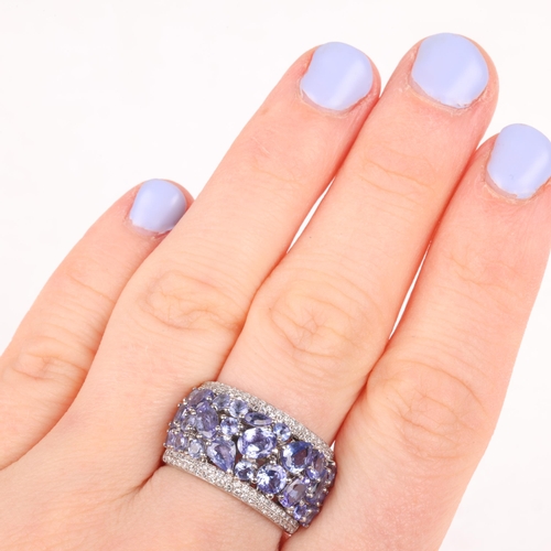 1228 - A 14ct white gold tanzanite and diamond band ring, by Effy, set with vari-cut tanzanites flanked by ... 