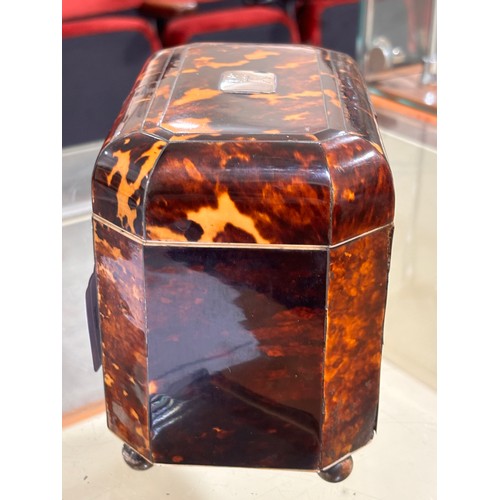 252 - An early 19th century tortoiseshell and silver inlaid tea caddy, with silver crest inset to the lid,... 