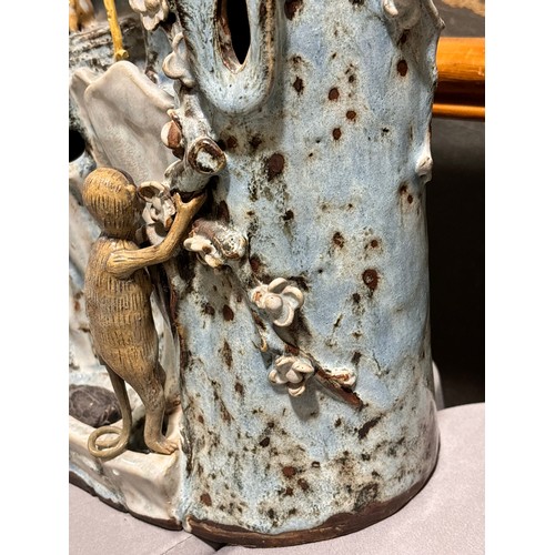 69 - A large Chinese glazed pottery table ornament, in the form of a figure with birds animals around a t... 