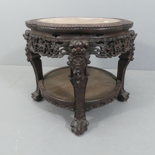 2048 - A Chinese hardwood two-tier Jardinière stand, with inset marble top, all over carved and pierced dec... 