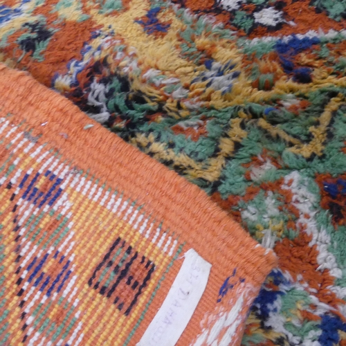 2295 - A large orange-ground tufted wool carpet. Length 225cm, width 175cm.