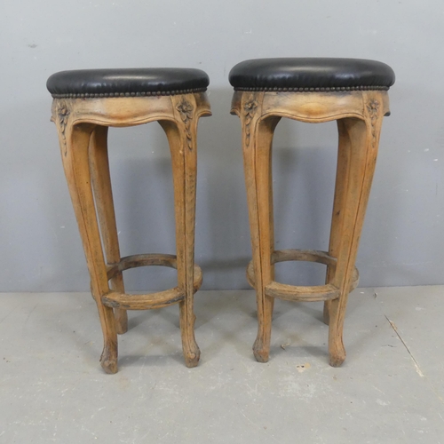 2340 - A pair of French oak and faux-leather upholstered bar stools. Height 76cm.