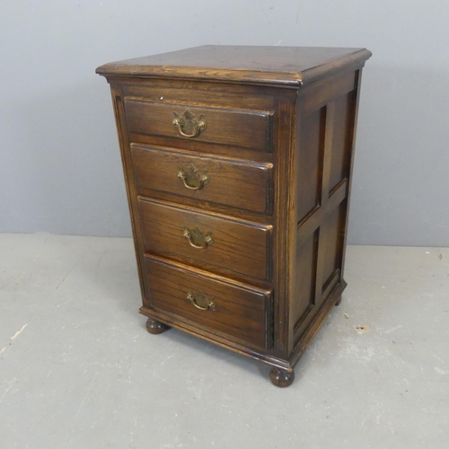 2357 - A panelled oak bedside chest of four drawers. Width 46cm, height 70cm, depth 40cm.