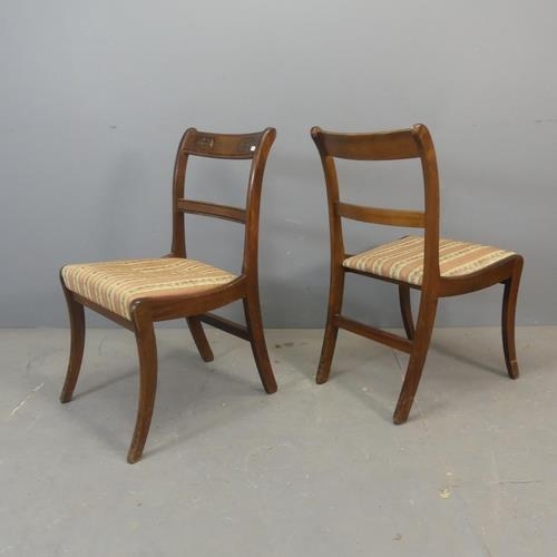 2438 - A set of four mahogany and upholstered Regency style dining chairs with inlaid brass decoration.