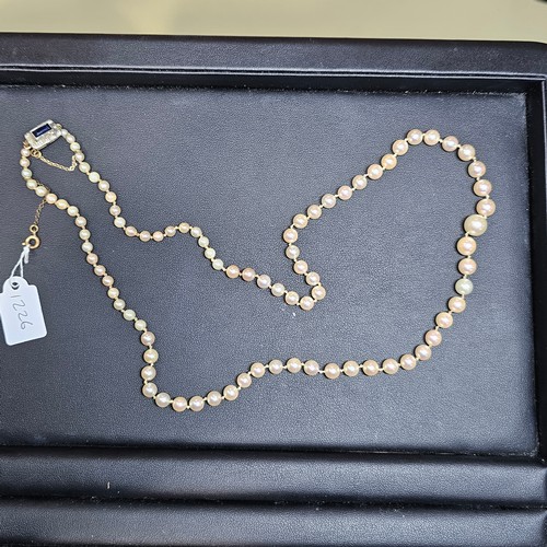 1226 - A single-strand pearl bead necklace, set with 8.1-3.3mm pearls, with 9ct gold synthetic? sapphire an... 