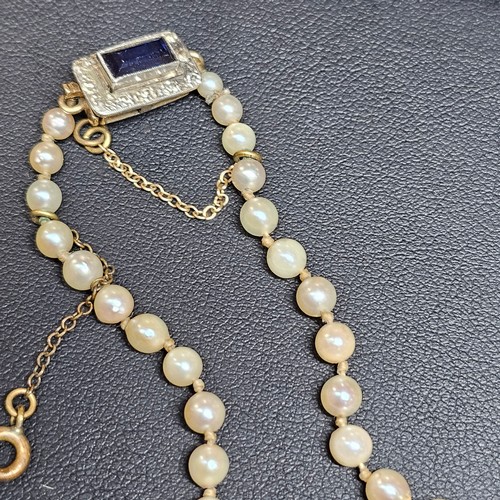 1226 - A single-strand pearl bead necklace, set with 8.1-3.3mm pearls, with 9ct gold synthetic? sapphire an... 