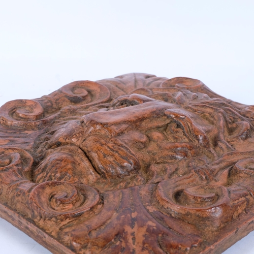 144 - A glazed lion mask terracotta wall plaque, 29cm x 29cm