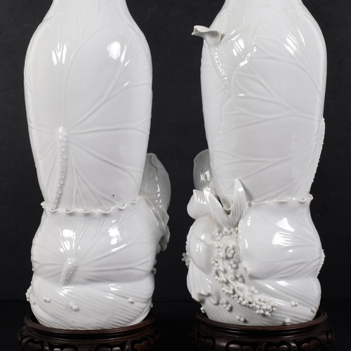 159 - A pair of Chinese blanc de chine vases, of textured form, with Koi carp decoration, on turned hardwo... 