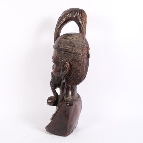 22 - An African carved hardwood bust of a Tribal elder smoking a pipe, 63cm