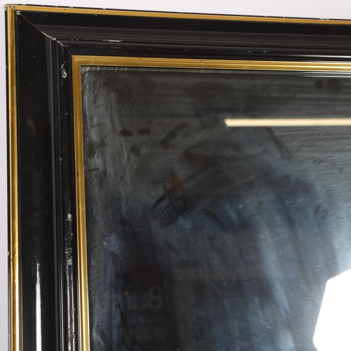 377 - A black and gilded rectangular wall mirror, 75cm x 52cm