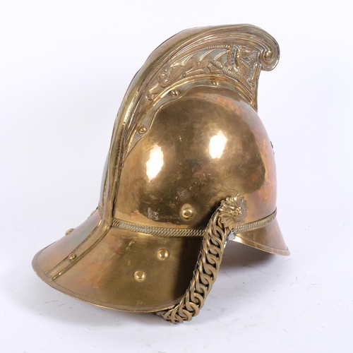 42 - A Victorian Merryweather pattern brass fireman's helmet, dragon embossed high comb, with chin strap ... 