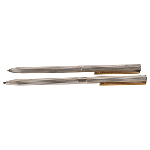 438 - 2 slimline sterling silver ballpoint pens with fluted bodies, both marked 925