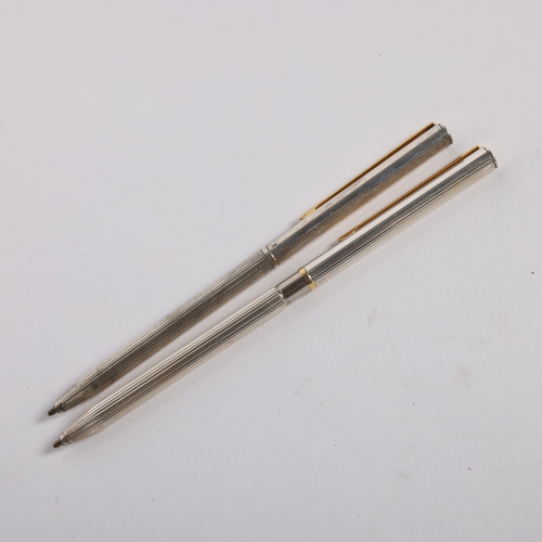 438 - 2 slimline sterling silver ballpoint pens with fluted bodies, both marked 925