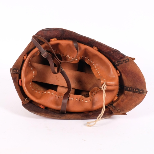 47 - A museum quality copy of a First World War tank driver's studded leather helmet, with chin strap and... 