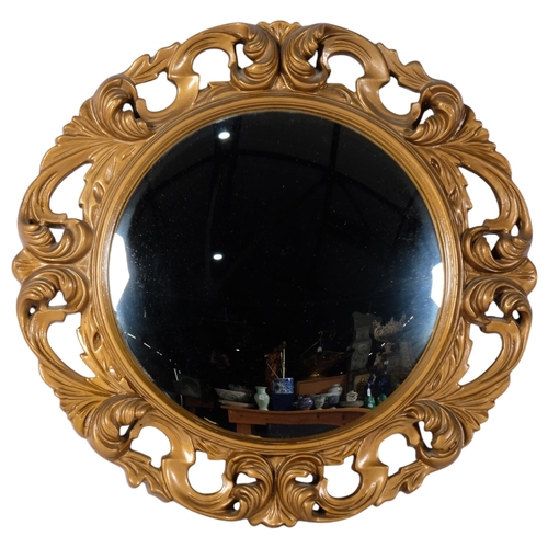 66 - A circular convex wall mirror, mounted in a scrolled gilt-gesso frame, diameter 51cm