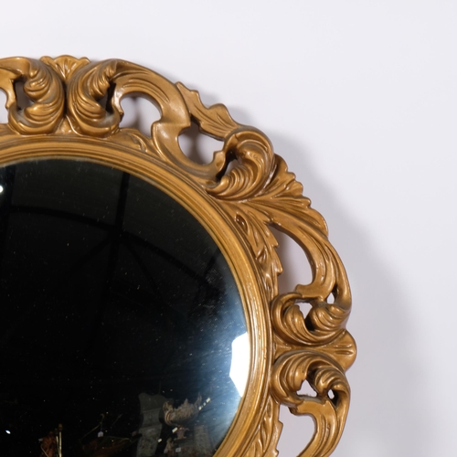 66 - A circular convex wall mirror, mounted in a scrolled gilt-gesso frame, diameter 51cm