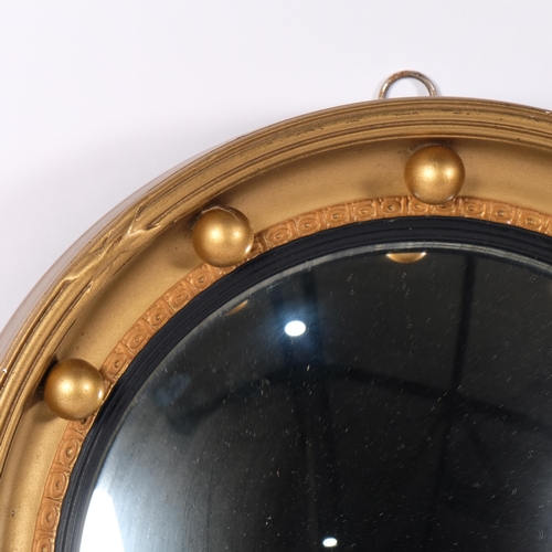 67 - A convex circular wall mirror, gilt-gesso framed with raised bosses, diameter 33cm