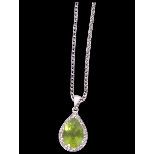 635 - A delicate 9ct white gold teardrop pendant and chain, set with a peridot and diamond surround, on an... 