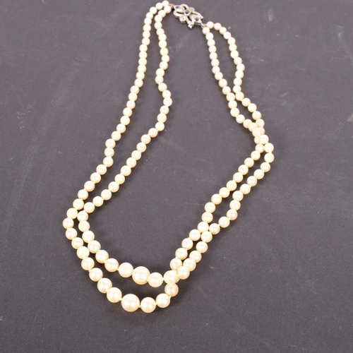 636 - An Art Deco style double-strand pearl necklace, set with a 9ct white gold clasp set with sapphires, ... 