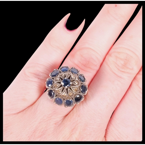 637 - A silver-gilt dress ring, set with 3 tiers of blue and white sapphires, size O