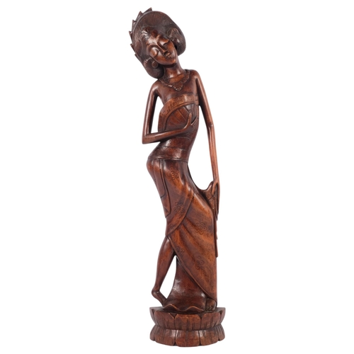 680 - A mid-20th century Balinese carved hardwood Art Deco figure of a dancer, signed AA Oka, 51cm