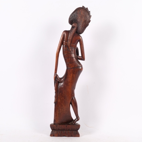 680 - A mid-20th century Balinese carved hardwood Art Deco figure of a dancer, signed AA Oka, 51cm