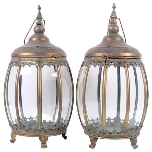 684 - A pair of glazed patinated metal hurricane lamps, on 4 feet, H48cm