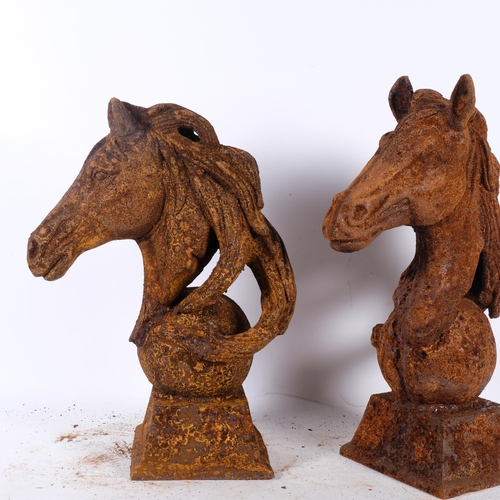 894 - A near pair of cast-iron horse heads on square plinths, tallest 47cm