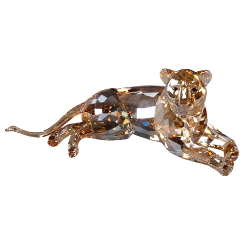 944 - SWAROVSKI - a tinted model of a recumbent lioness, 18cm, boxed