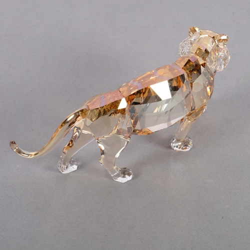 948 - SWAROVSKI - a tinted model of a prowling tiger, L19cm, boxed with certificate of authenticity