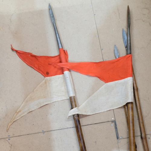 964 - A pair of bamboo lances/spears, with red and white pennants, the steel tips dated 1914, and a pair o... 