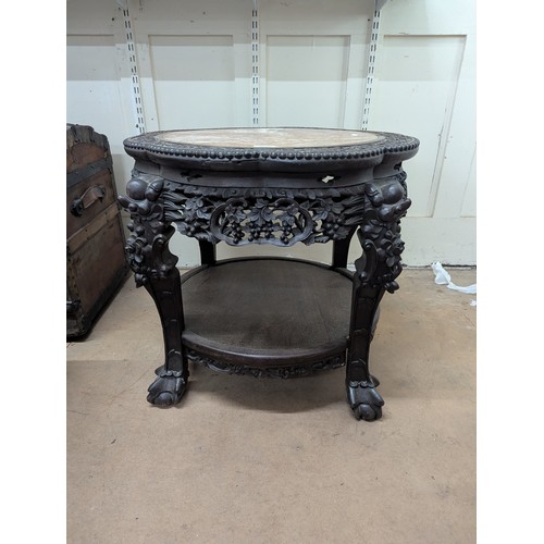 2048 - A Chinese hardwood two-tier Jardinière stand, with inset marble top, all over carved and pierced dec... 