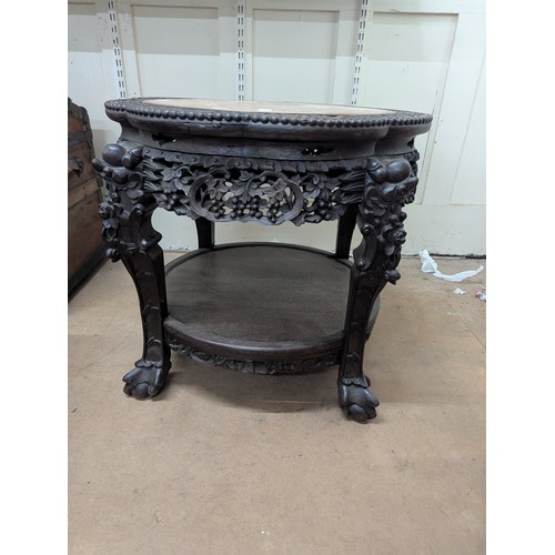 2048 - A Chinese hardwood two-tier Jardinière stand, with inset marble top, all over carved and pierced dec... 