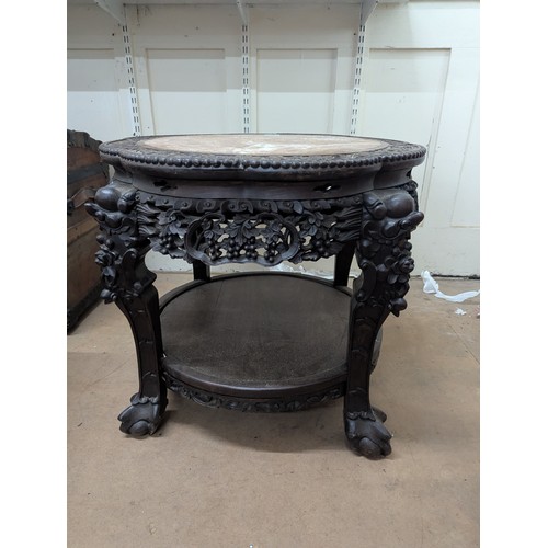 2048 - A Chinese hardwood two-tier Jardinière stand, with inset marble top, all over carved and pierced dec... 